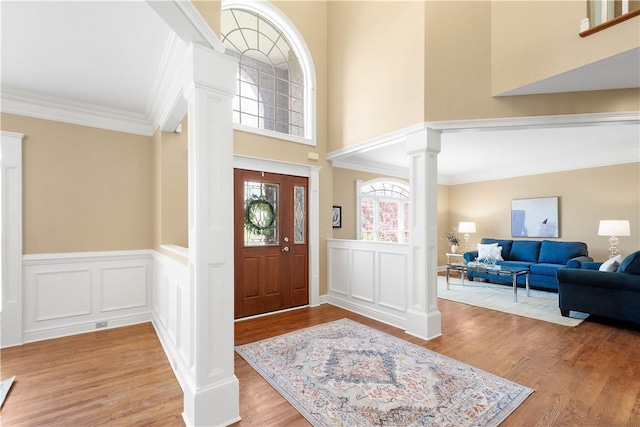 8010 Sherwood Dr, Collier Twp, PA 15142 - entrance foyer with decorative columns, a decorative wall, light wood-style flooring, crown molding, and a towering ceiling