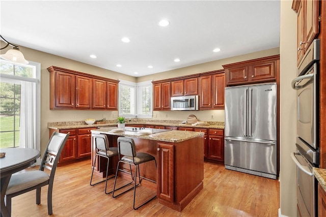 8010 Sherwood Dr, Collier Twp, PA 15142 - kitchen featuring appliances with stainless steel finishes, healthy amount of natural light, light wood finished floors, a kitchen island, and recessed lighting