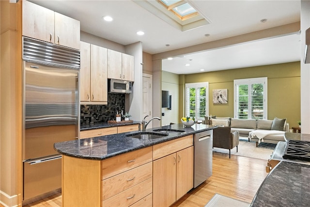 140 N Woodland Rd, Shadyside, PA 15232 - kitchen with stainless steel appliances, light wood-style flooring, dark stone countertops, a skylight, and recessed lighting