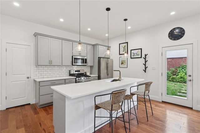 3130 Dobson St, Polish Hill, PA 15219 - kitchen with stainless steel appliances, gray cabinets, an island with sink, decorative backsplash, and recessed lighting