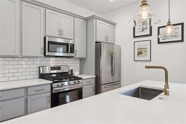 3130 Dobson St, Polish Hill, PA 15219 - kitchen with stainless steel appliances, gray cabinets, decorative backsplash, light countertops, and hanging light fixtures