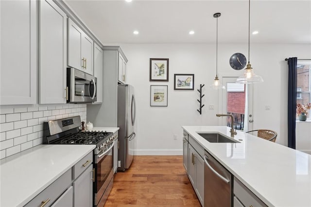 3130 Dobson St, Polish Hill, PA 15219 - kitchen featuring stainless steel appliances, gray cabinets, light wood-type flooring, light countertops, and backsplash