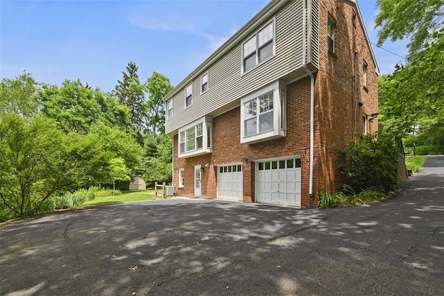 195 Grandview Dr N, Fox Chapel, PA 15215 - view of side of home featuring asphalt driveway, brick siding, and an attached garage