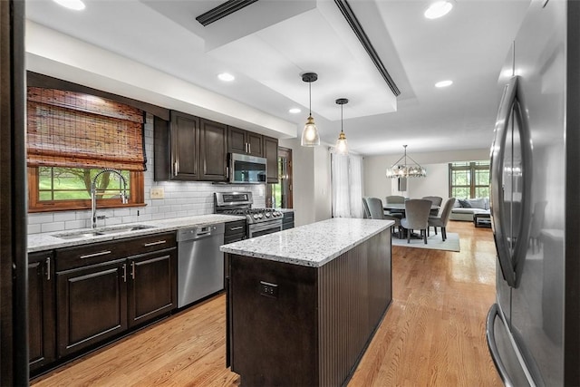 2616 Cedarvue Dr, Upper St Clair, PA 15241 - kitchen featuring stainless steel appliances, light wood finished floors, a kitchen island, light stone countertops, and hanging light fixtures