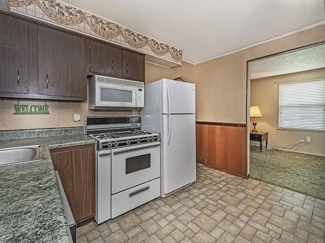 2665 Warrendale Bayne Rd, Marshall, PA 15005 - kitchen with white appliances, dark countertops, brick patterned floors, a wainscoted wall, and dark brown cabinets