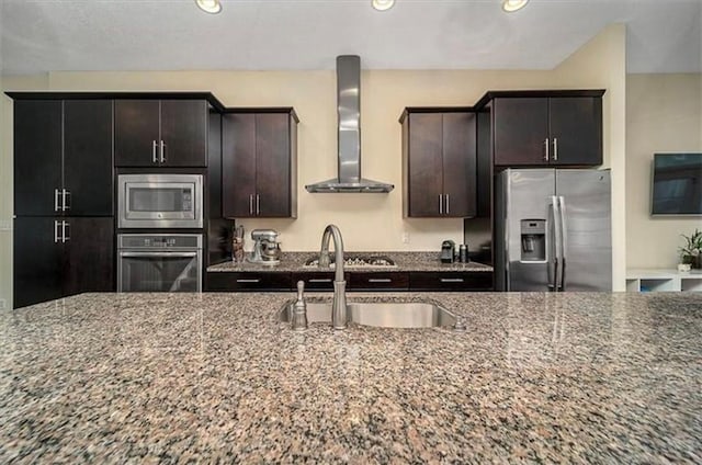 323 Osona Ln, Marshall, PA 16046 - kitchen featuring appliances with stainless steel finishes, wall chimney range hood, dark stone counters, recessed lighting, and dark brown cabinets
