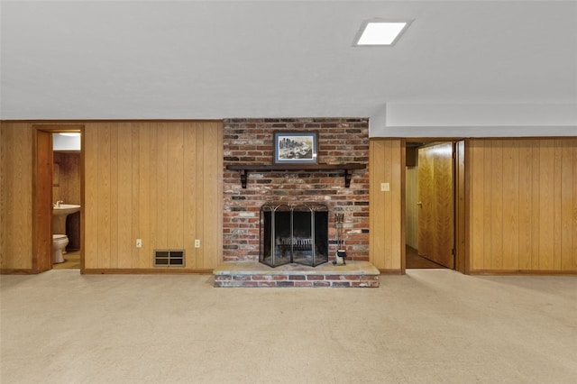 103 Drood Ln, Ross Twp, PA 15237 - unfurnished living room with wood walls, carpet flooring, and a brick fireplace
