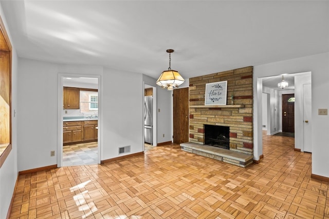 103 Drood Ln, Ross Twp, PA 15237 - unfurnished living room featuring a stone fireplace and a chandelier