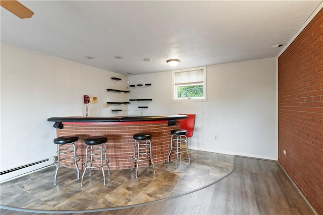 130 Clare Dr, South Strabane, PA 15301 - indoor dry bar featuring wood finished floors, a baseboard radiator, and brick wall