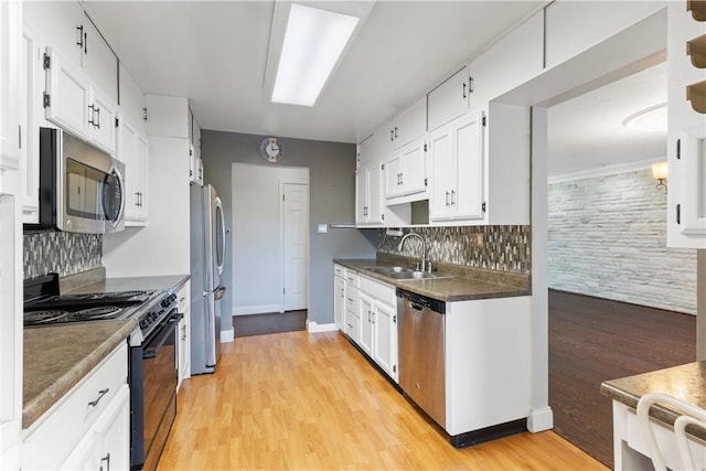 130 Clare Dr, South Strabane, PA 15301 - kitchen featuring appliances with stainless steel finishes, tasteful backsplash, light wood-type flooring, and white cabinetry