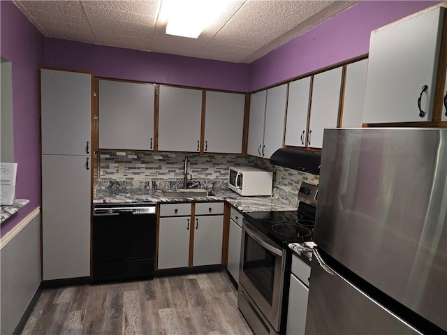 1987 Centurion Dr Unit 202, Forest Hills Boro, PA 15221 - kitchen featuring appliances with stainless steel finishes, light wood finished floors, tasteful backsplash, range hood, and white cabinetry