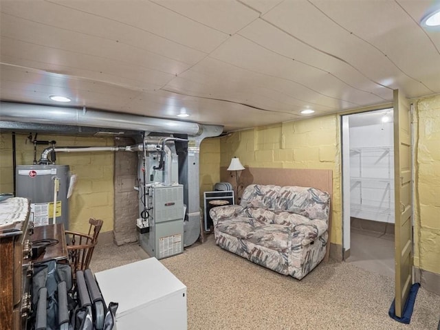 finished below grade area with gas water heater, heating unit, recessed lighting, and fridge