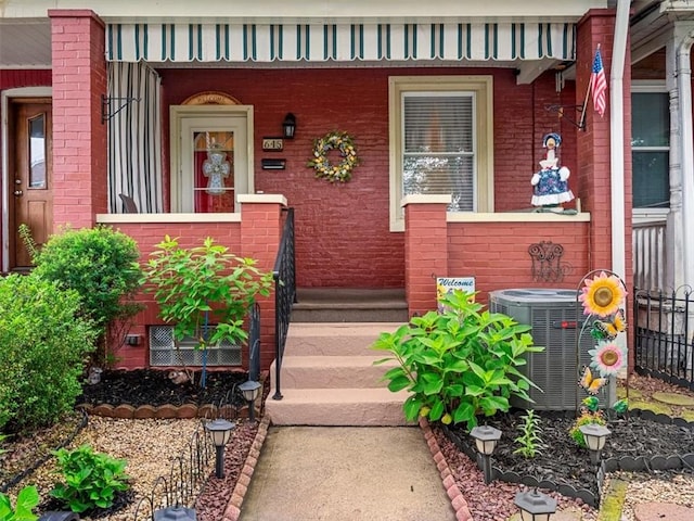 entrance to property featuring brick siding and a porch