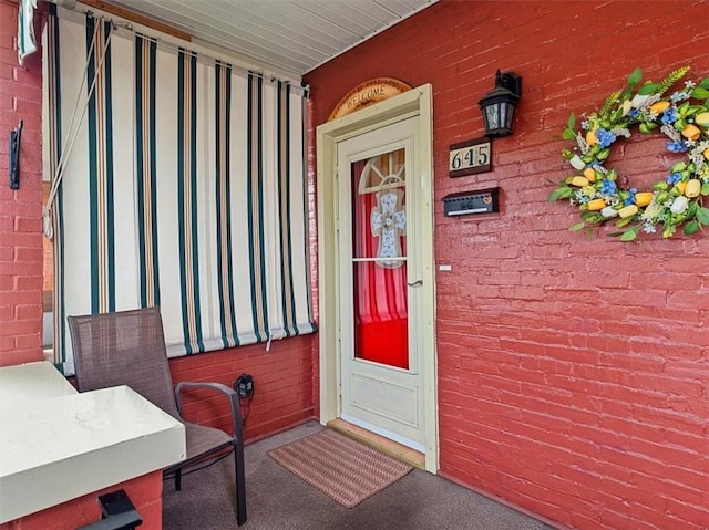 view of exterior entry featuring brick siding