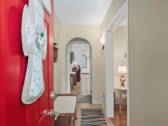 entrance foyer with arched walkways and wood finished floors