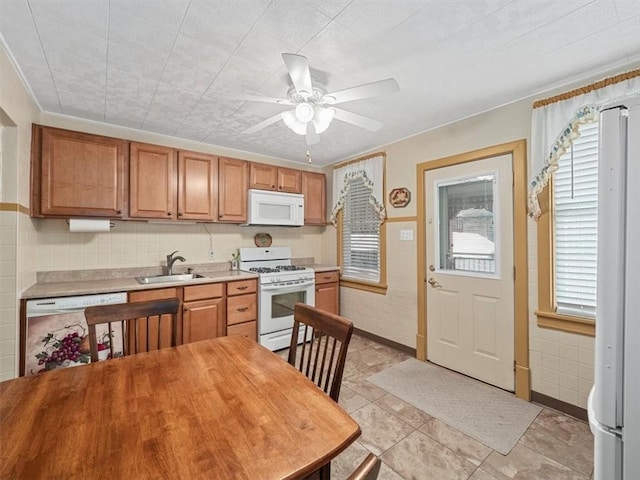 kitchen with white appliances, healthy amount of natural light, light countertops, and ceiling fan
