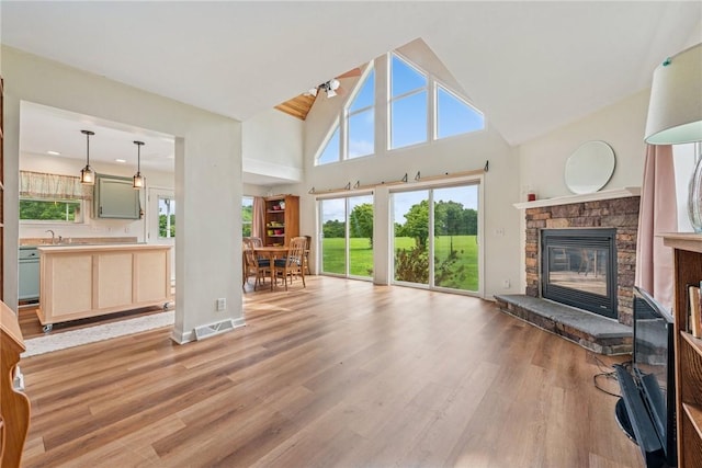 135 Preacher Rd, East Huntingdon, PA 15639 - living room with light wood-style floors, high vaulted ceiling, and a stone fireplace