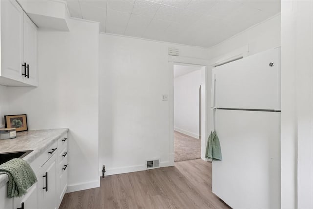 1571 Baldwick Rd, Banksville/Westwood, PA 15205 - kitchen with freestanding refrigerator, white cabinetry, light wood-style floors, light countertops, and ornamental molding