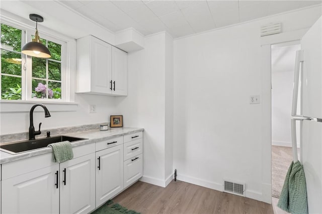 1571 Baldwick Rd, Banksville/Westwood, PA 15205 - kitchen with light wood-style flooring, white cabinets, freestanding refrigerator, and light countertops