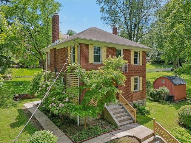 1571 Baldwick Rd, Banksville/Westwood, PA 15205 - view of front facade featuring a chimney, a storage shed, brick siding, a front yard, and stairway