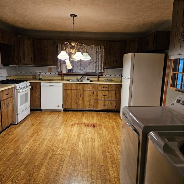 111 Laughlin St, Dawson, PA 15428 - kitchen featuring white appliances, light wood finished floors, light countertops, a chandelier, and a textured ceiling
