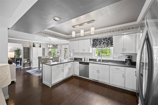 1008 Aspen Dr, Findlay Twp, PA 15126 - kitchen with stainless steel appliances, a peninsula, ornamental molding, white cabinets, and dark wood-style floors