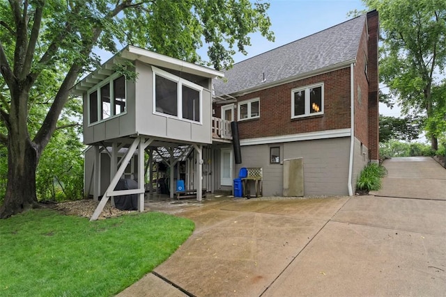 36 Warriors Rd, Green Tree, PA 15205 - back of house featuring brick siding, a sunroom, roof with shingles, a patio area, and a lawn