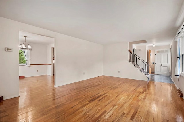 100 Laurel Hill Dr, Pine Twp Nal, PA 15090 - unfurnished living room featuring light wood-style flooring, a chandelier, and stairway