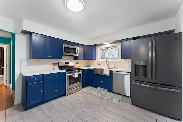624 S Darby Rd, Hermitage, PA 16148 - kitchen with stainless steel appliances, blue cabinets, light countertops, wood finish floors, and decorative backsplash