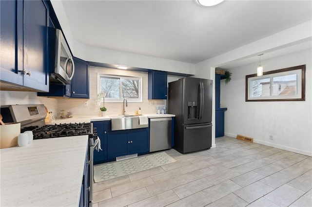 624 S Darby Rd, Hermitage, PA 16148 - kitchen featuring stainless steel appliances, blue cabinetry, light countertops, decorative backsplash, and hanging light fixtures