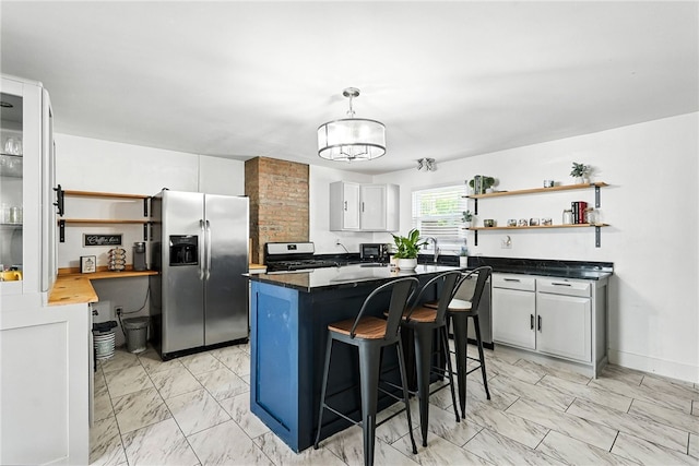 2740 Shelly St, South Side, PA 15203 - kitchen featuring stainless steel appliances, open shelves, light marble finish floors, a breakfast bar, and a center island