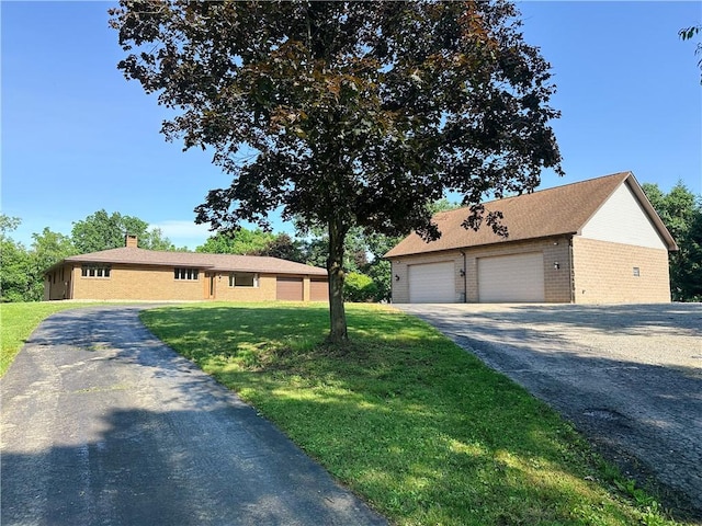 150 Morgan Rd, Penn Twp But, PA 16002 - view of front of property featuring a detached garage, an outdoor structure, a front yard, brick siding, and a chimney