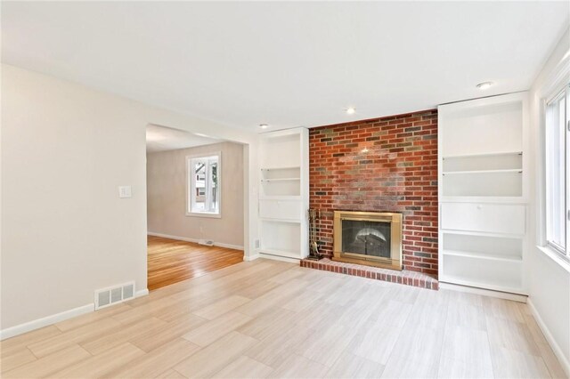 1154 Bucknell, Monroeville, PA 15146 - unfurnished living room with light wood-style floors, built in shelves, plenty of natural light, a brick fireplace, and recessed lighting