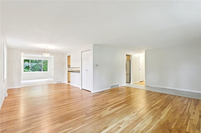 1154 Bucknell, Monroeville, PA 15146 - unfurnished living room with light wood-style floors and a chandelier