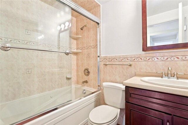 1154 Bucknell, Monroeville, PA 15146 - bathroom featuring combined bath / shower with glass door, vanity, and tile walls