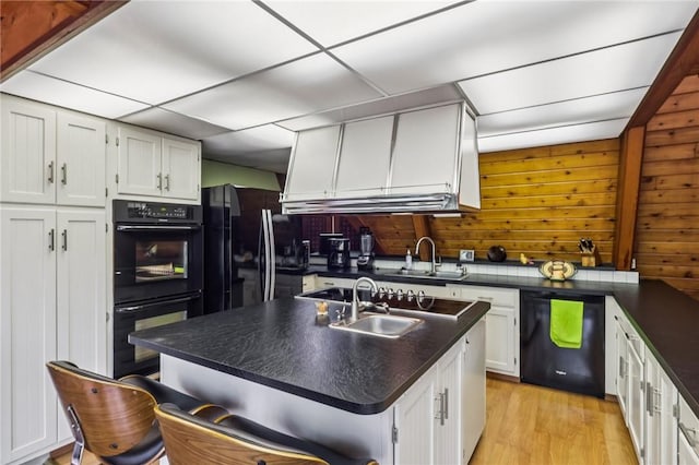890 Pearce Mill Rd, Pine Twp Nal, PA 15090 - kitchen featuring black appliances, dark countertops, white cabinetry, a breakfast bar area, and light wood finished floors