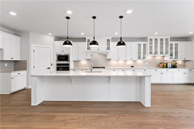 107 Abigail Dr, Adams Twp, PA 16046 - kitchen with black oven, stainless steel microwave, backsplash, white cabinets, and light countertops