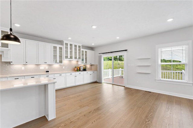 107 Abigail Dr, Adams Twp, PA 16046 - kitchen featuring light countertops, decorative backsplash, white cabinetry, light wood-style floors, and glass insert cabinets