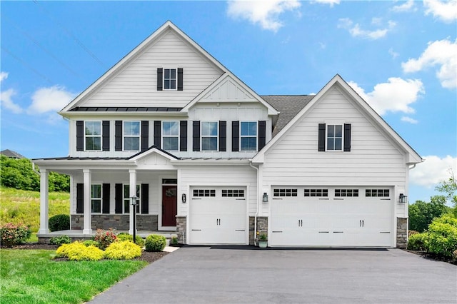 107 Abigail Dr, Adams Twp, PA 16046 - view of front of house featuring a garage, a porch, driveway, a standing seam roof, and stone siding