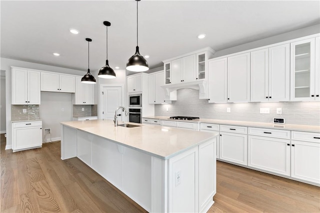 107 Abigail Dr, Adams Twp, PA 16046 - kitchen with stainless steel appliances, decorative backsplash, light wood-type flooring, recessed lighting, and an island with sink