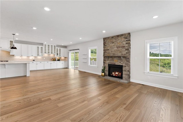 107 Abigail Dr, Adams Twp, PA 16046 - unfurnished living room with a stone fireplace, light wood-style flooring, and recessed lighting