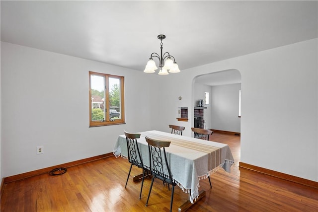 138 Link Ave, Ross Twp, PA 15237 - dining area with arched walkways, wood finished floors, a chandelier, and a fireplace