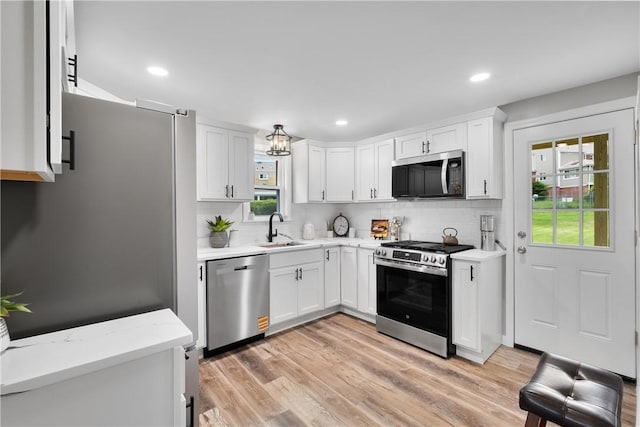 746 Agnew Rd, Baldwin Boro, PA 15227 - kitchen with stainless steel appliances, decorative backsplash, white cabinetry, light wood finished floors, and recessed lighting