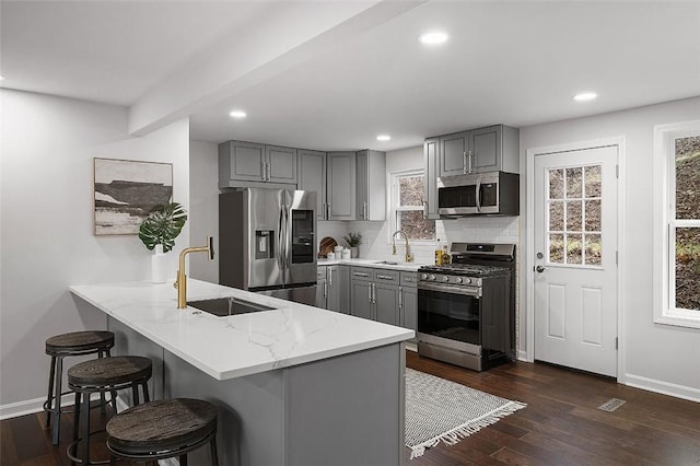 1171 Arrowood Dr, Mt Lebanon, PA 15243 - kitchen with appliances with stainless steel finishes, gray cabinets, a peninsula, a kitchen bar, and recessed lighting