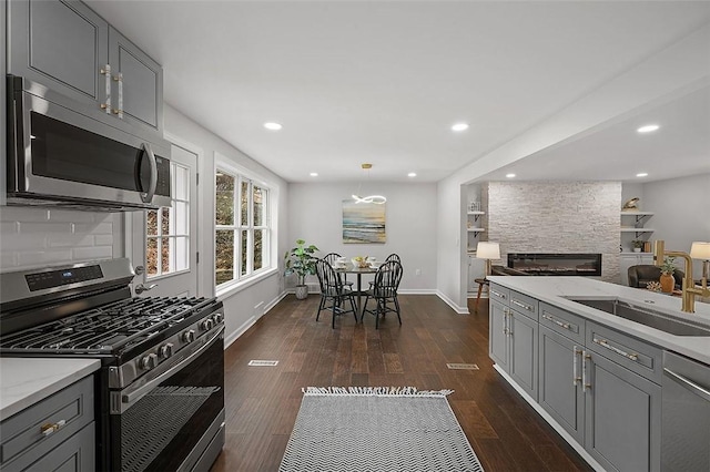 1171 Arrowood Dr, Mt Lebanon, PA 15243 - kitchen featuring stainless steel appliances, gray cabinetry, dark wood-style floors, a fireplace, and recessed lighting