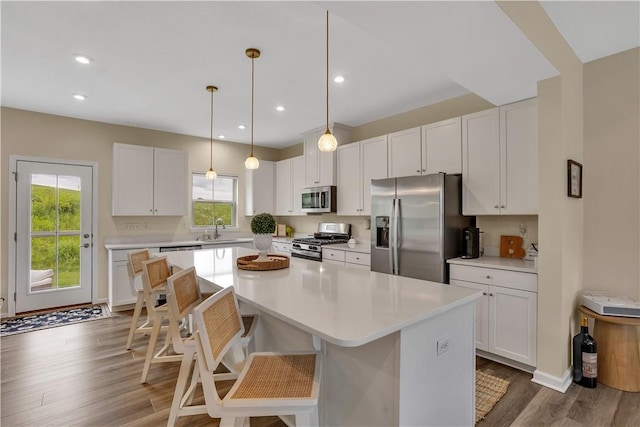 2005 Lampl Ln, Penn Twp Wml, PA 15644 - kitchen with appliances with stainless steel finishes, a center island, white cabinetry, wood finished floors, and recessed lighting