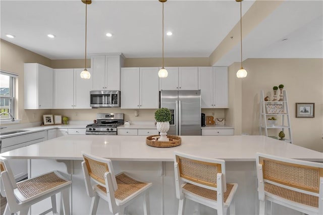 2005 Lampl Ln, Penn Twp Wml, PA 15644 - kitchen with appliances with stainless steel finishes, a kitchen island, light countertops, white cabinets, and pendant lighting