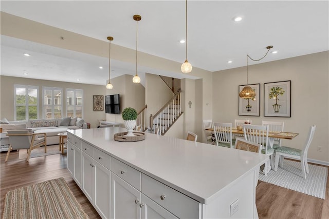 2005 Lampl Ln, Penn Twp Wml, PA 15644 - kitchen with wood finished floors, white cabinets, light countertops, pendant lighting, and a kitchen island