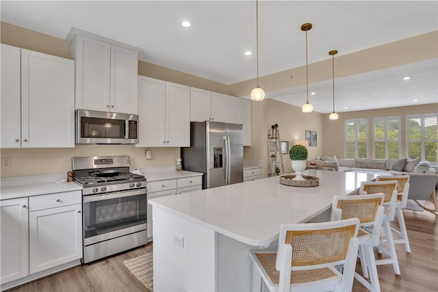 2005 Lampl Ln, Penn Twp Wml, PA 15644 - kitchen with stainless steel appliances, light wood-style flooring, open floor plan, light countertops, and white cabinetry