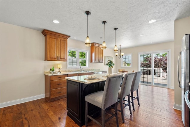 445/447 Georgetown Rd, Cecil, PA 15055 - kitchen with brown cabinets, a breakfast bar, recessed lighting, dark wood-style flooring, and a kitchen island